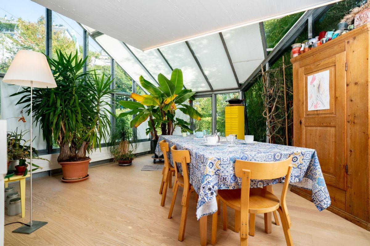 Wintergarten mit Esstisch und Pflanzen