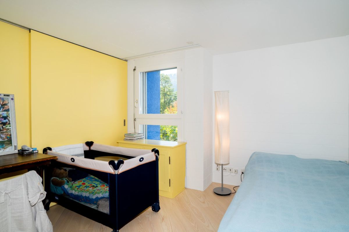Kinder-/Schlafzimmer mit gelber Wand, großem Fenster und Spielbett