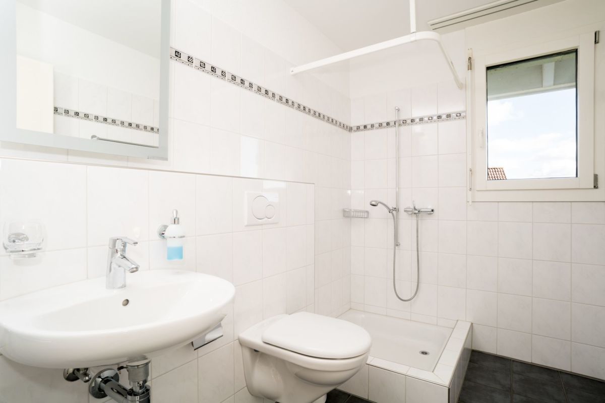 Helles, kleines Badezimmer mit Dusche und Fenster