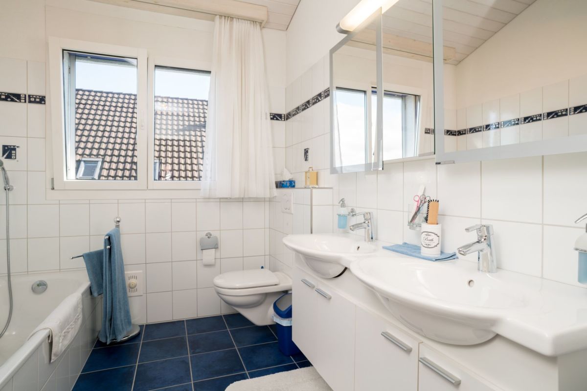Helles Badezimmer mit Doppelwaschtisch und Wanne