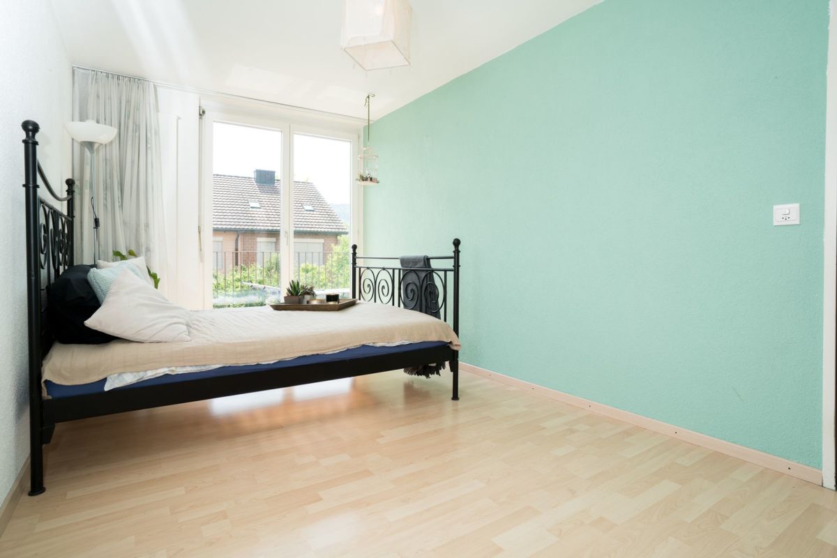 Helles Schlafzimmer mit schmiedeeisernem Bett