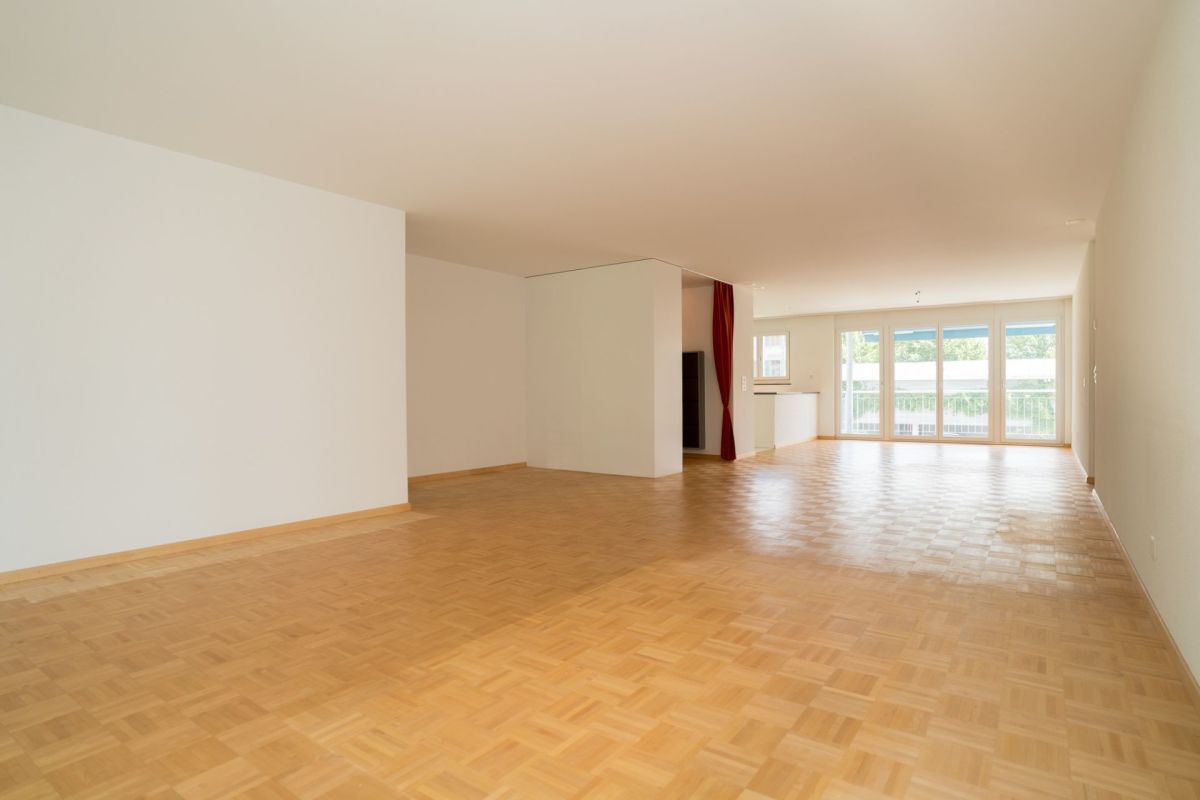 Großer leerer Wohnraum mit Parkettboden