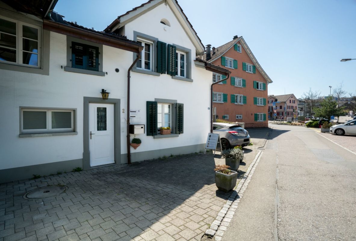 Straßenansicht eines Hauses mit grünen Fensterläden
