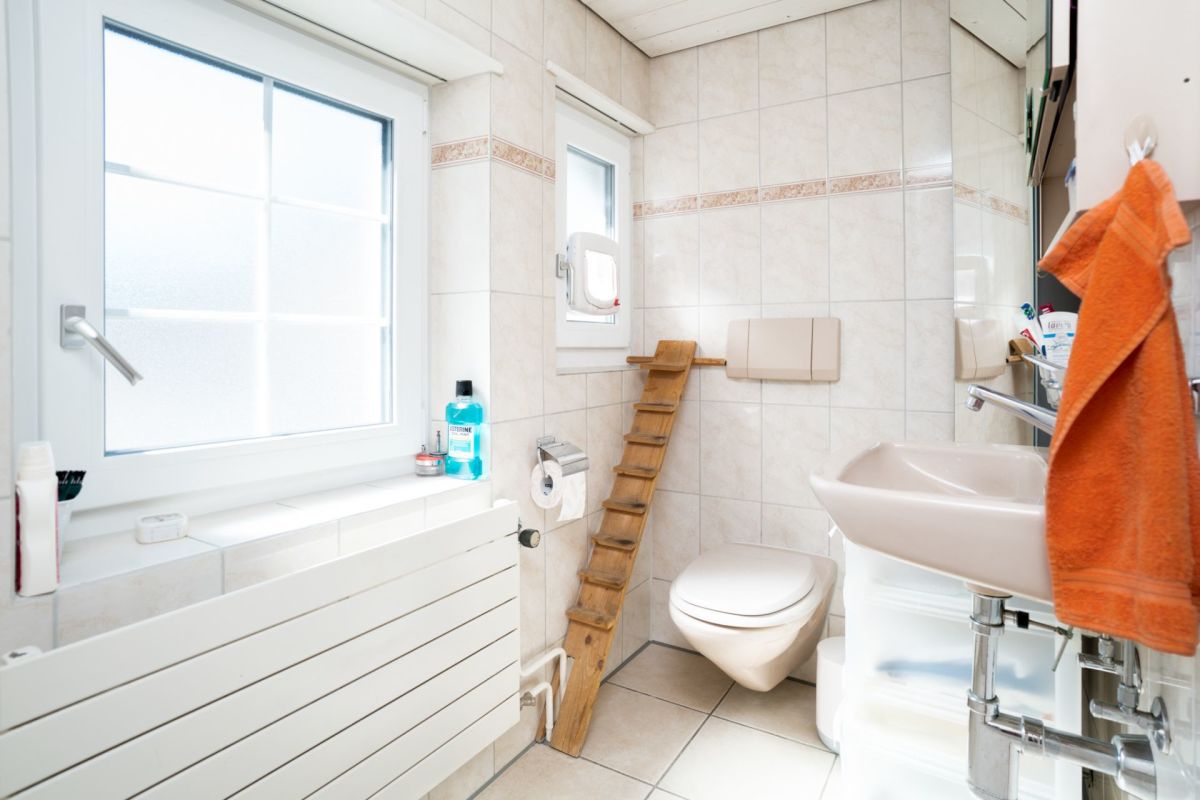 Helles Badezimmer mit Fenster und WC