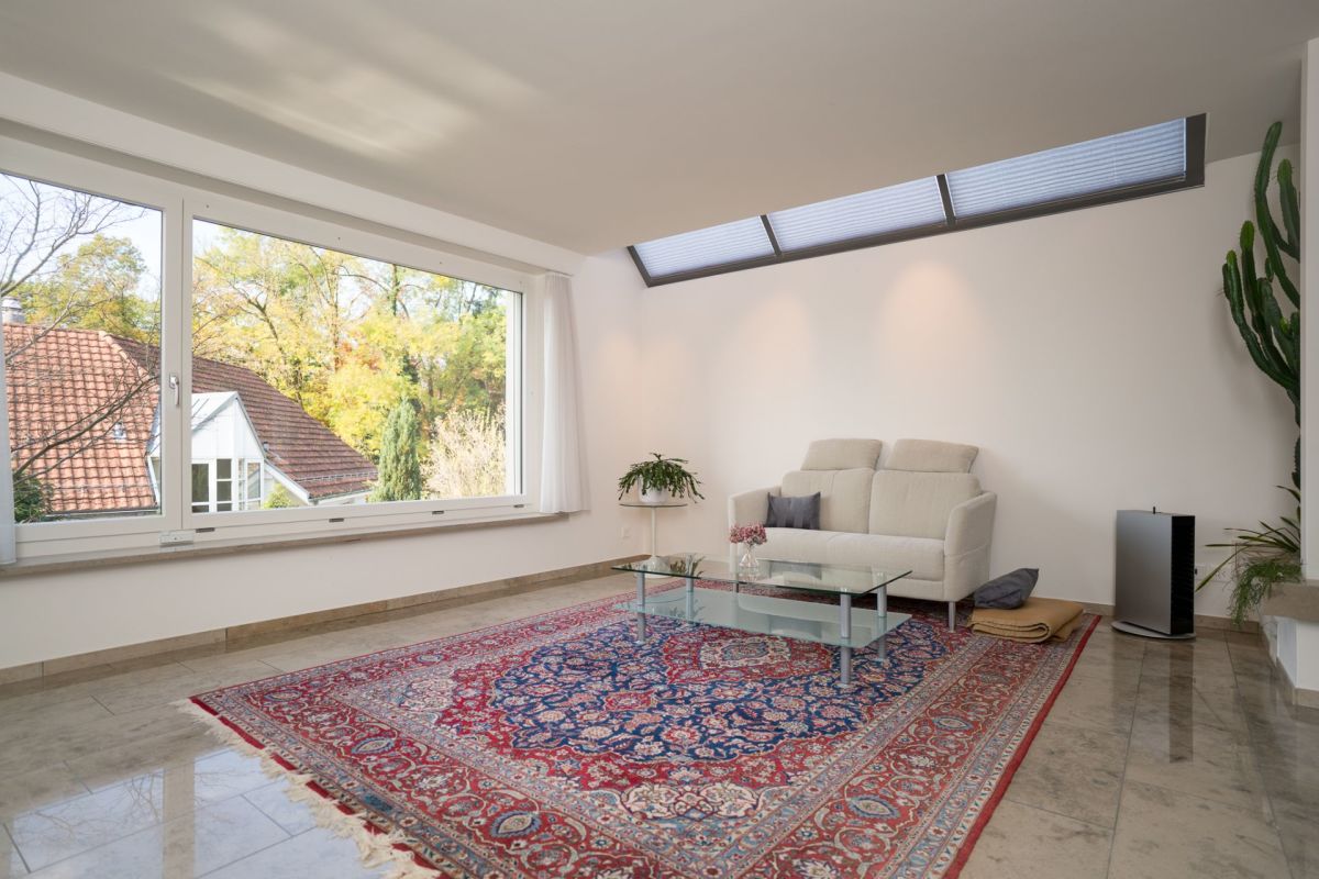Heller Wohnraum mit großem Fenster und Teppich