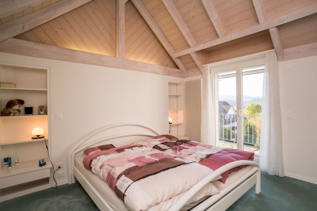 Dachgeschoss-Schlafzimmer mit Holzbalken