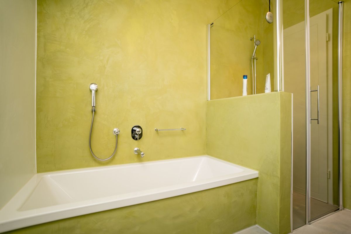 Modernes Badezimmer mit gelbgrünen Wänden und Badewanne