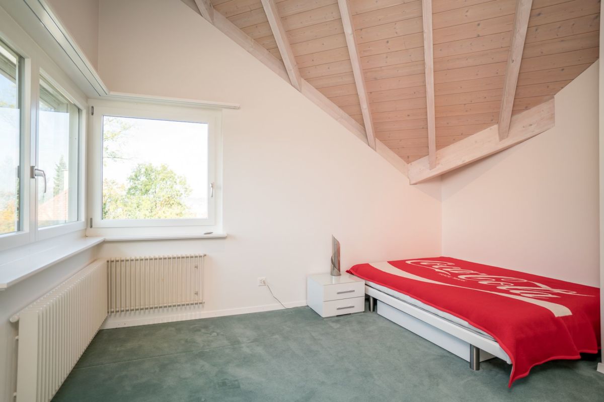 Dachzimmer mit Bett und Fenster