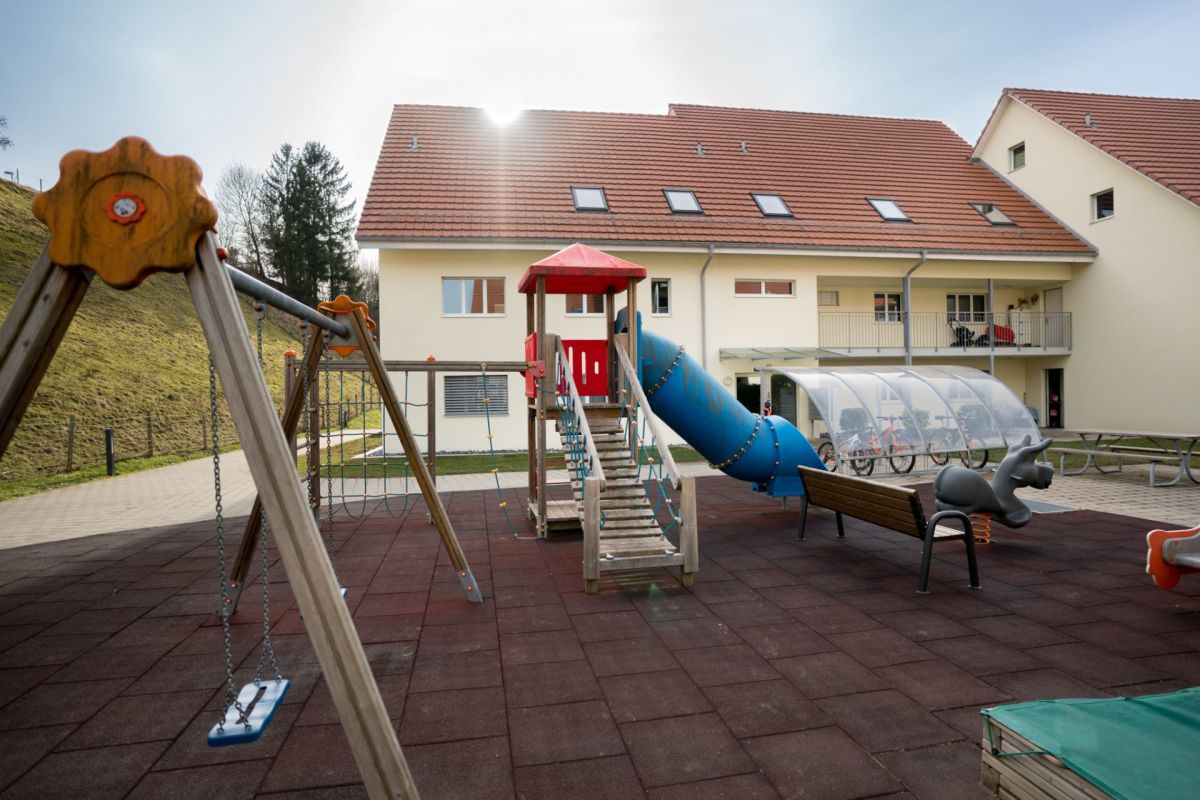 Außenbereich mit Spielplatz vor Mehrfamilienhaus