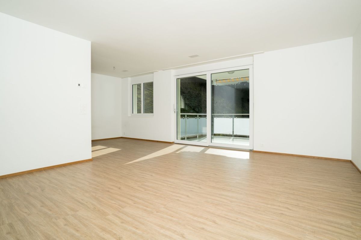 Heller, leerer Wohnraum mit Balkonzugang
