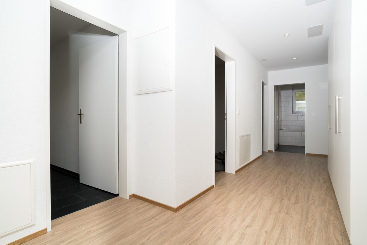 Heller Flur mit Holzoptikboden und weißen Türen