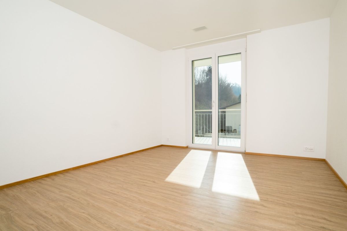 Helles, leeres Zimmer mit Balkonzugang