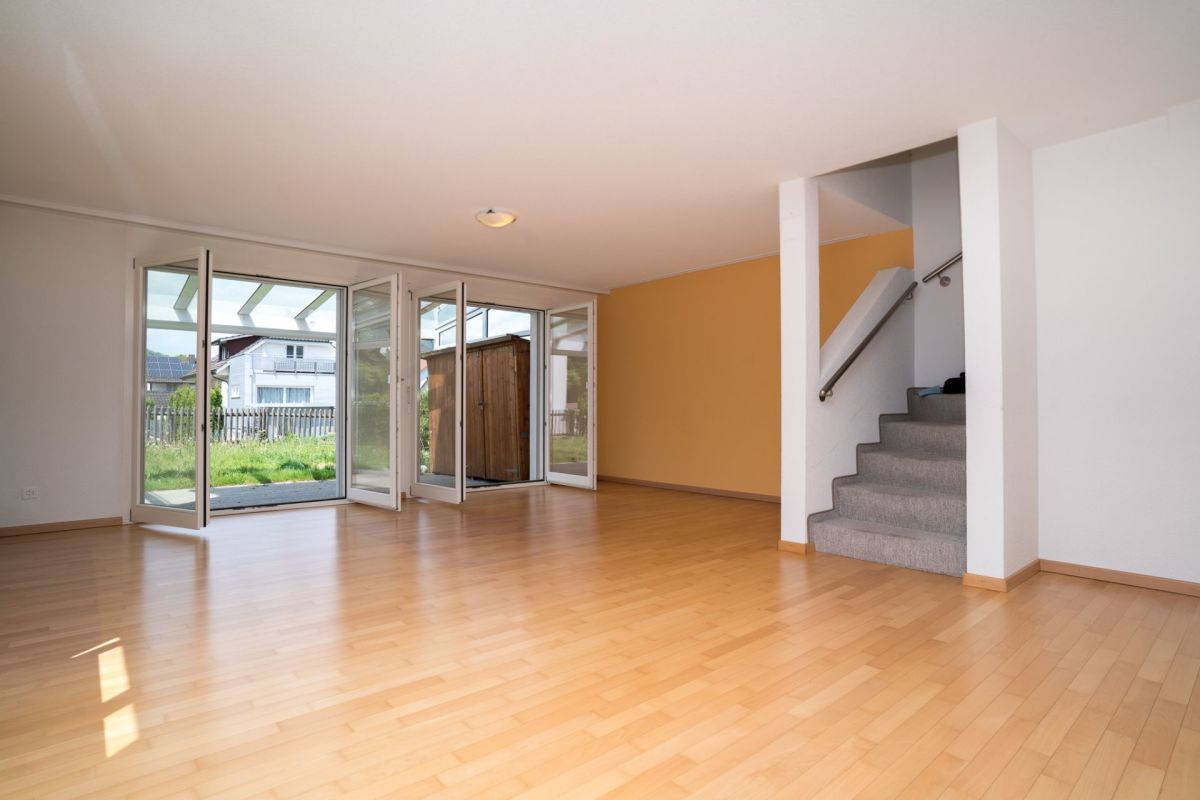 Heller Wohnraum mit Treppe und Gartenzugang