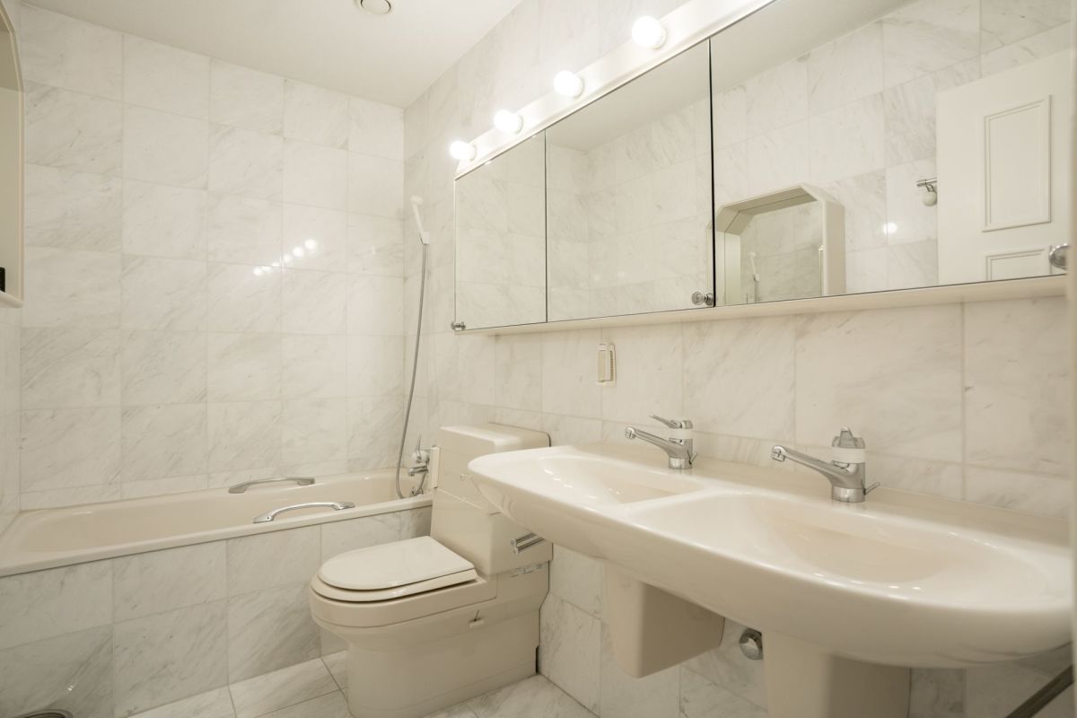 Helles Badezimmer mit Badewanne, Doppelwaschtisch und großem Spiegelschrank