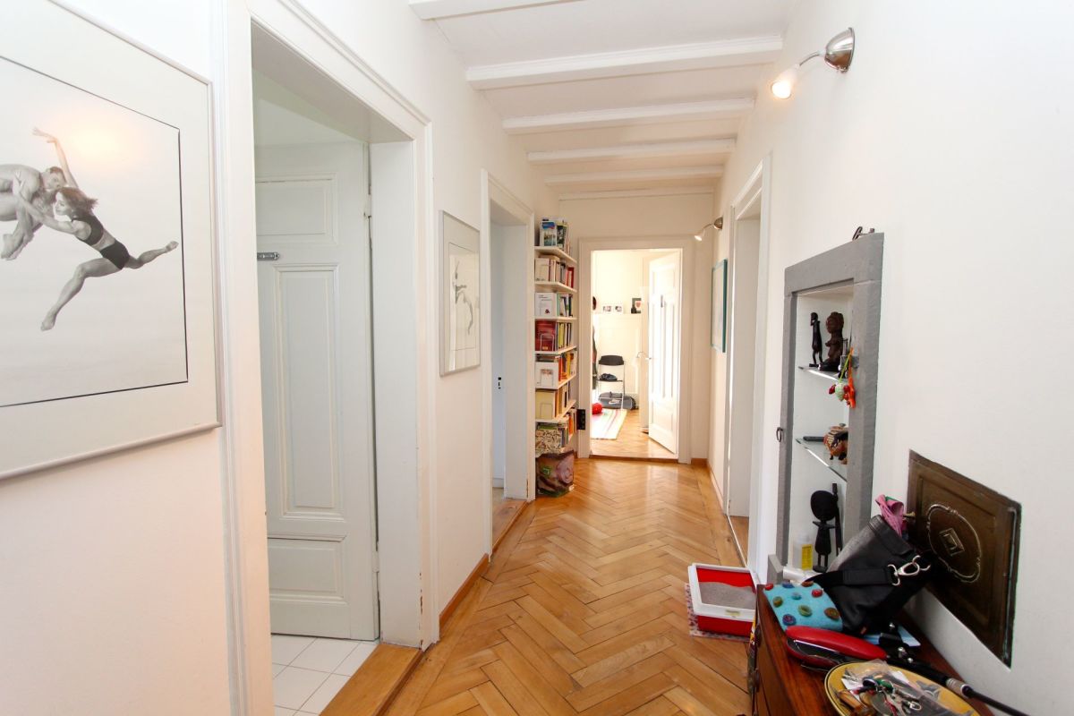 Heller Flur mit Holzboden und klassischen Türen