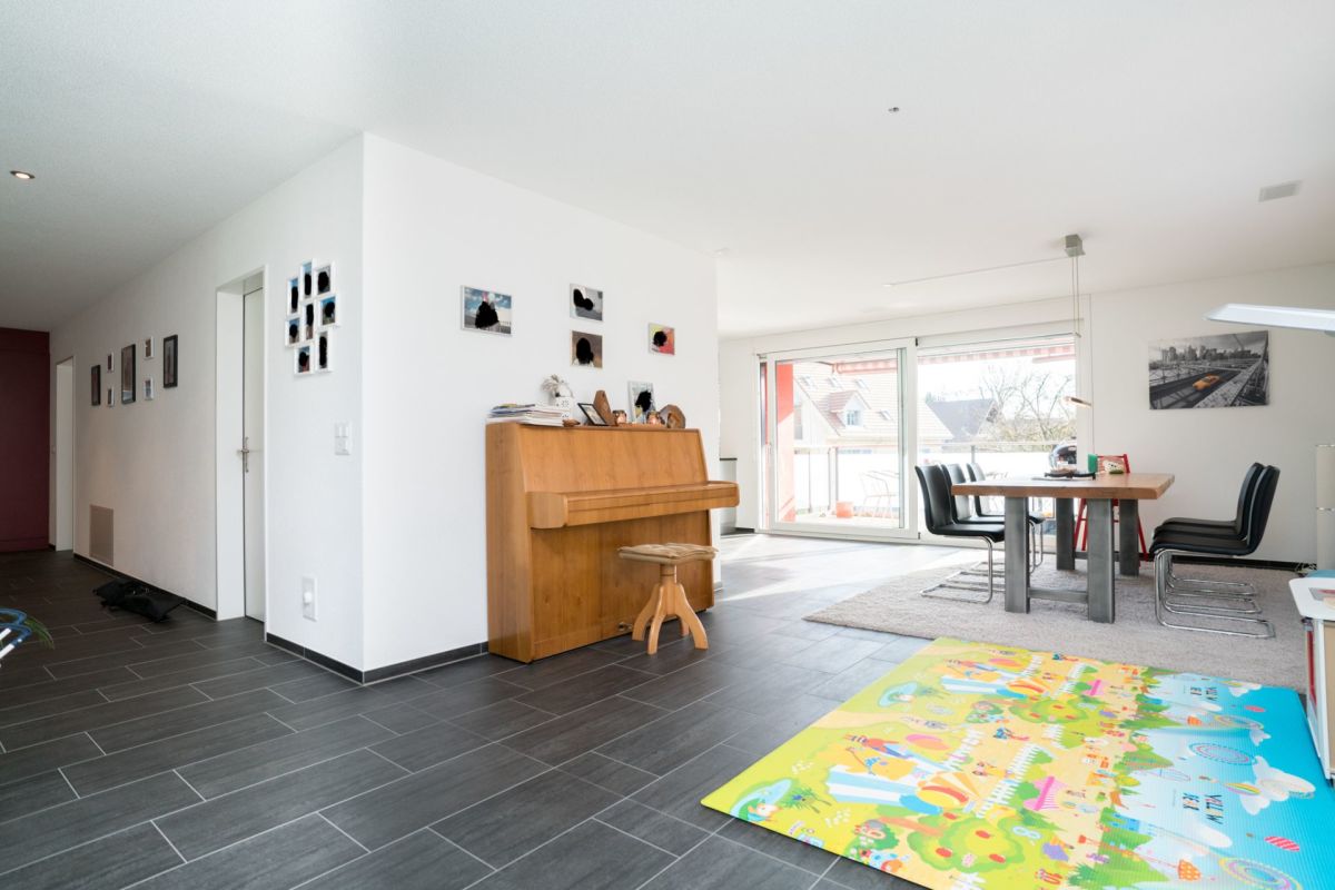 Offener Wohn-Essbereich mit Piano und Balkonblick