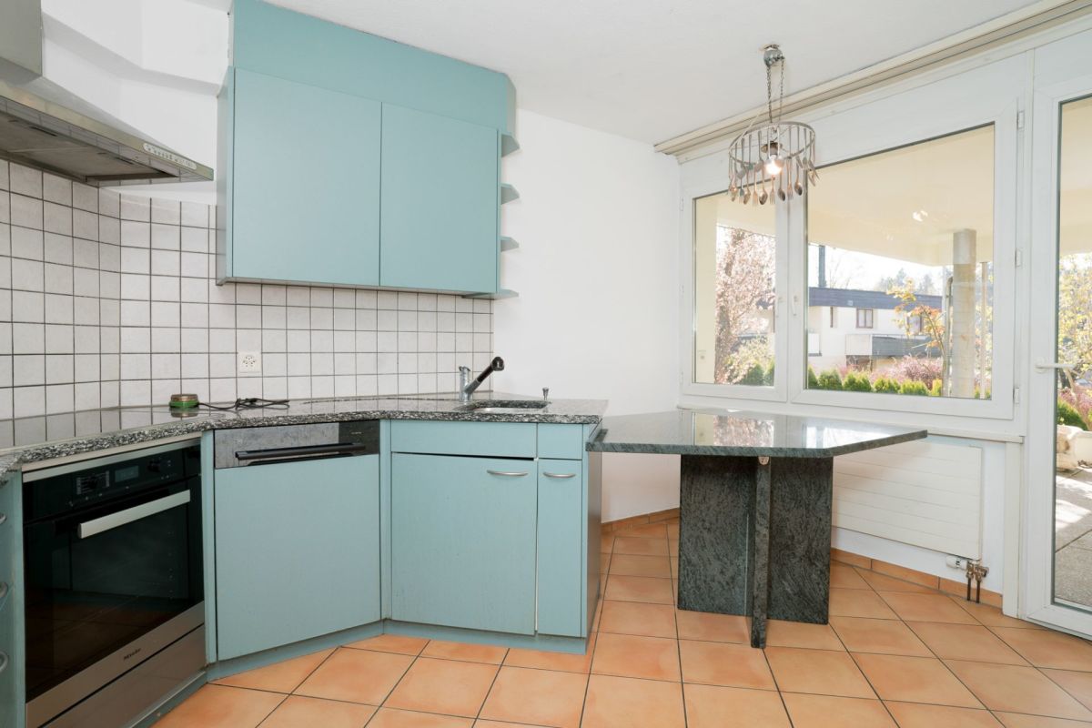 Helle Küche mit Terrassentür und Gartenblick