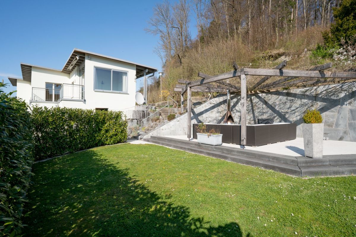 Moderner Garten mit Terrasse und Hausansicht