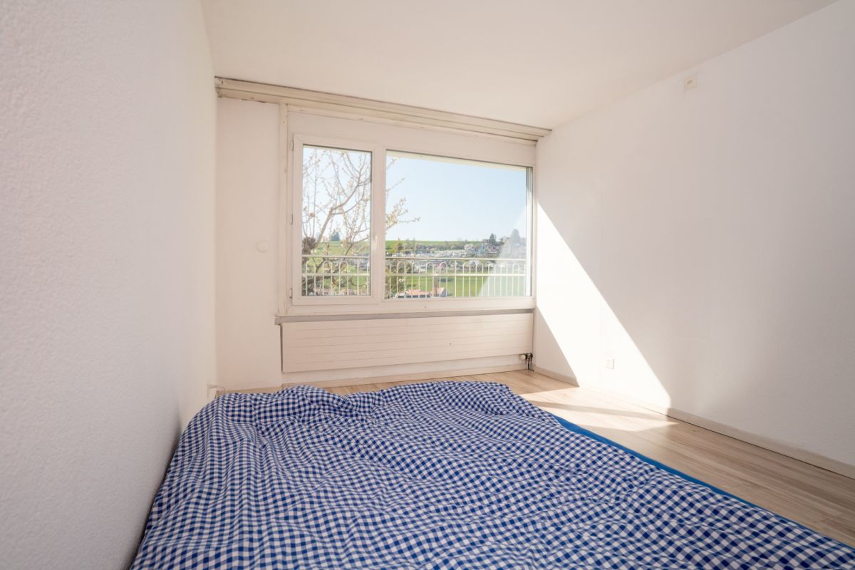 Schlichtes Schlafzimmer mit großem Fenster