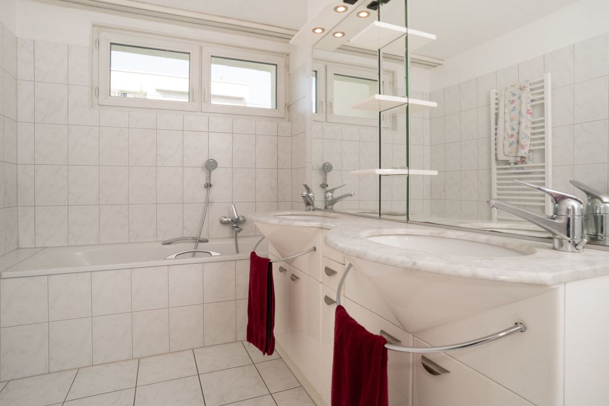 Helles Badezimmer mit Doppelwaschtisch und Badewanne