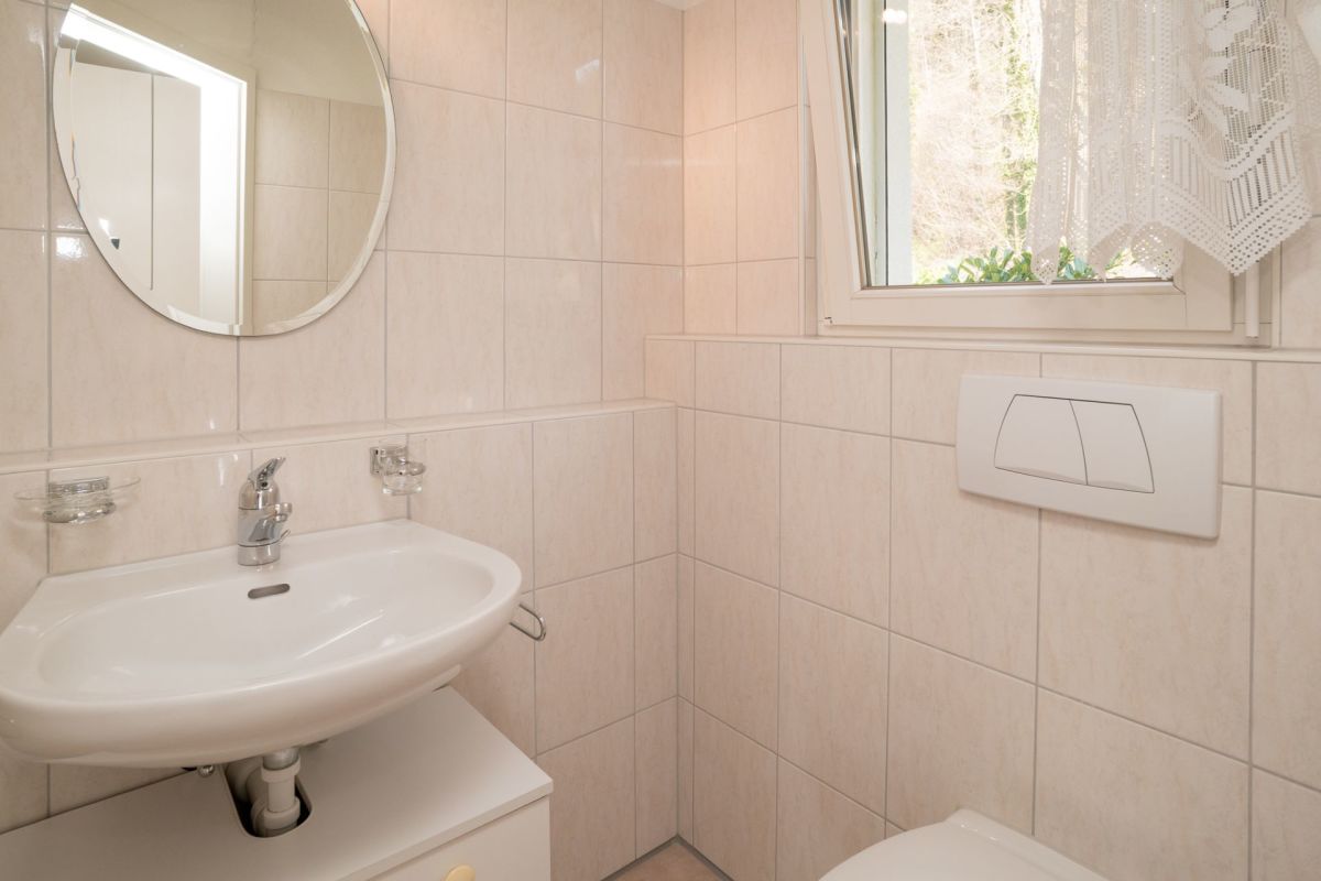 Helles Gäste-WC mit Waschbecken und Fenster