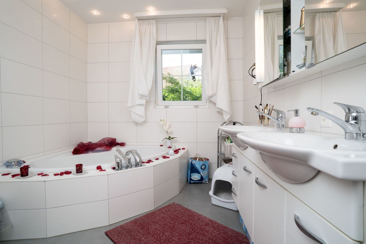 Helles Badezimmer mit Eckbadewanne und Doppelwaschtisch