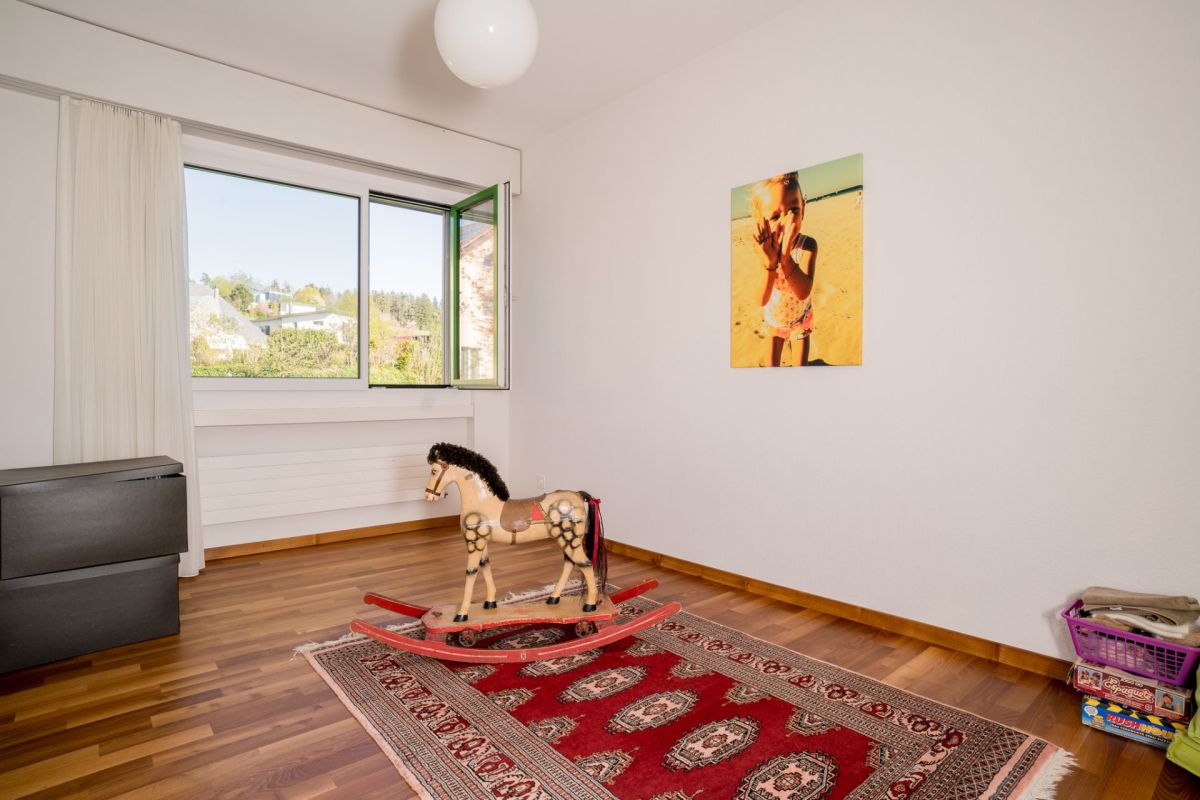 Helles, schlichtes Schlafzimmer mit Fenster und Teppich