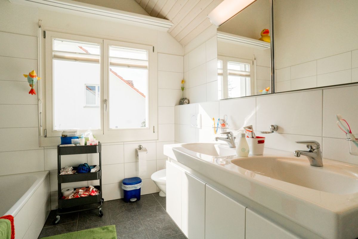 Helles Badezimmer mit Doppelwaschbecken und Badewanne