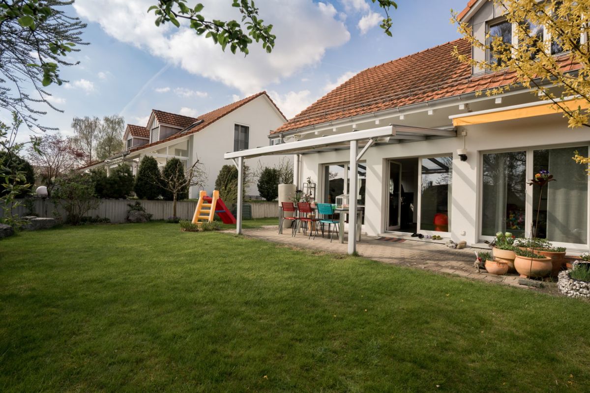 Gartenansicht eines Einfamilienhauses mit Terrasse