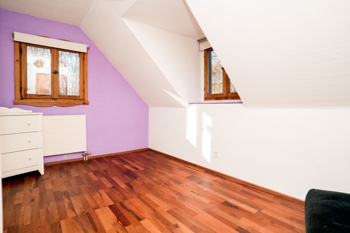Dachzimmer mit Holzfenstern und violetter Wand