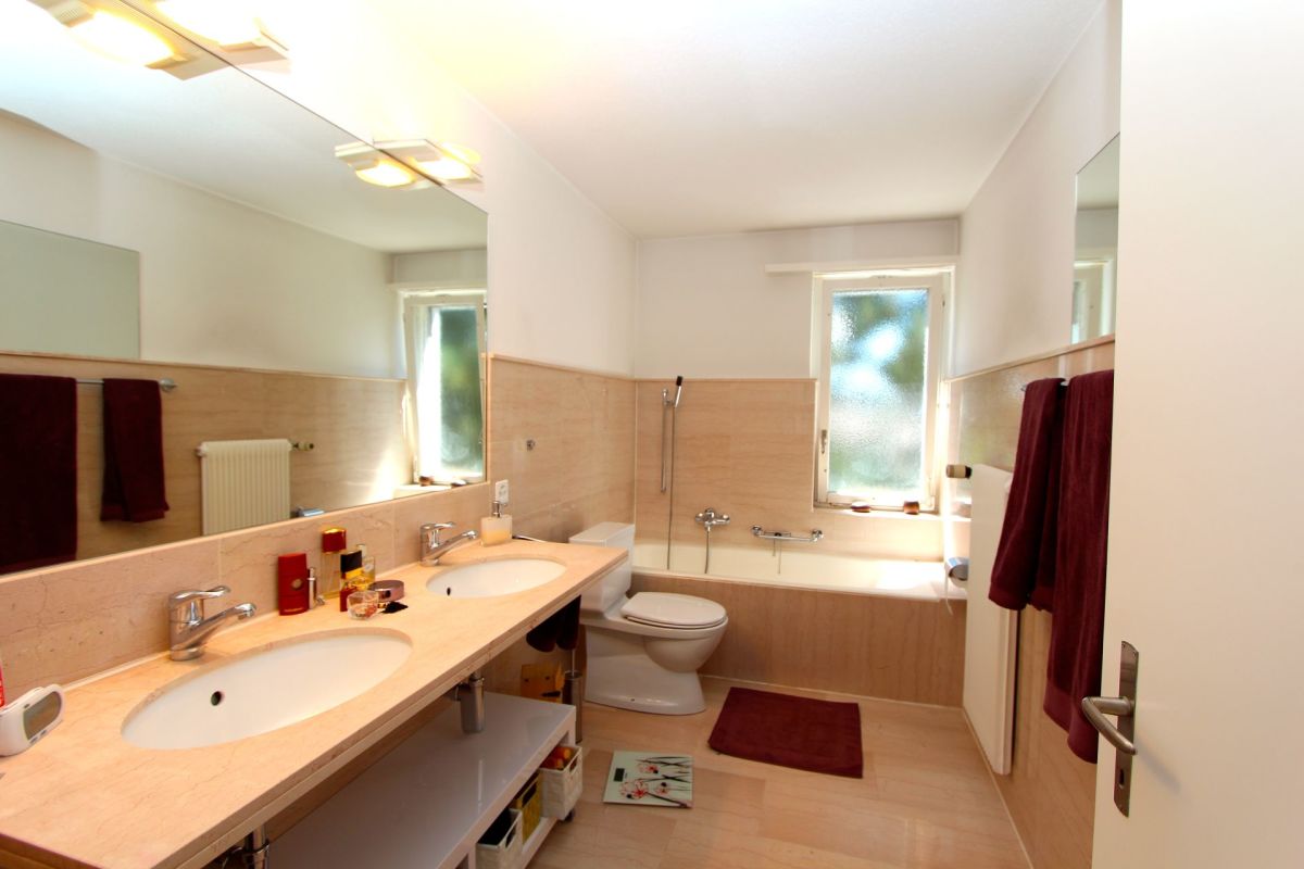 Helles Badezimmer mit Doppelwaschtisch und Badewanne