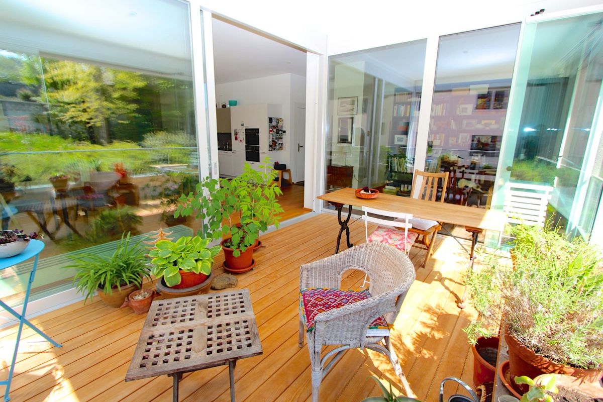 Helle Glasveranda mit Holzterrasse