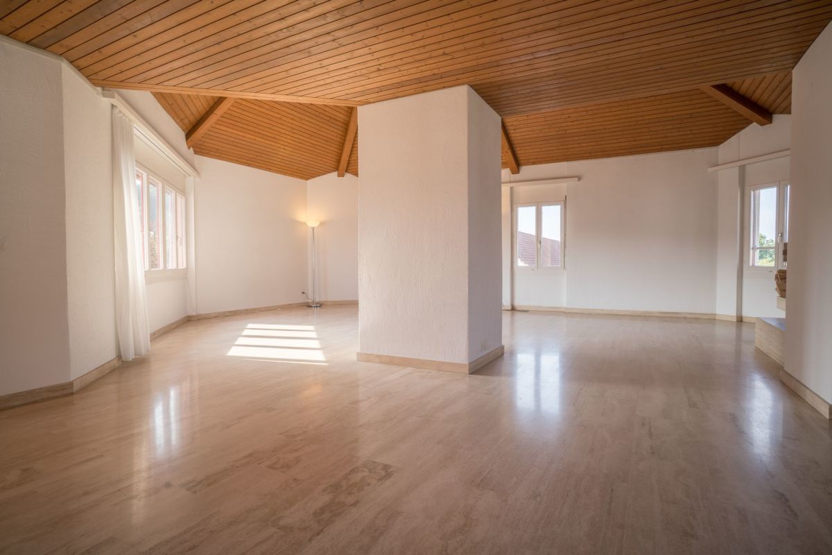 Großer leerer Wohnraum mit Holzdecke