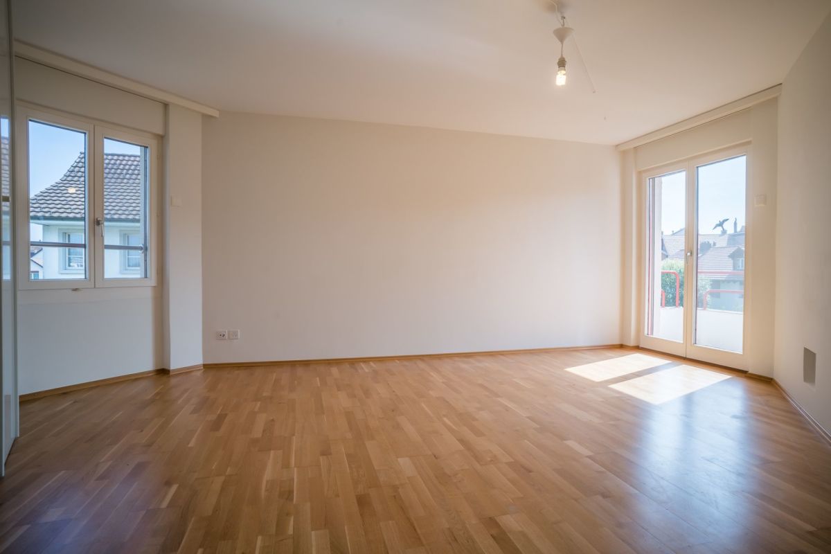 Heller leerer Wohnraum mit großen Fenstern