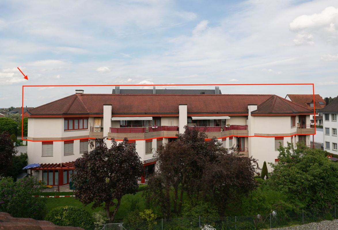 Mehrfamilienhaus mit rotem Satteldach und Gartenansicht