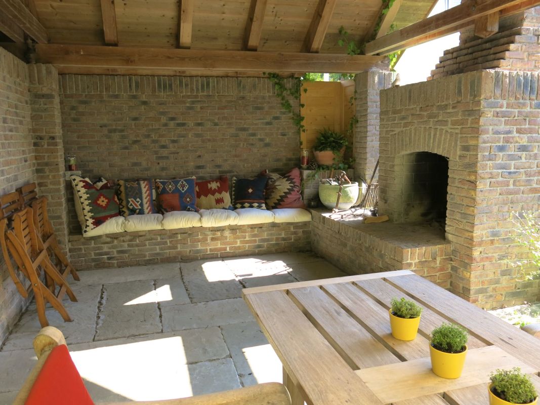 Überdachter Brick-Outdoor-Sitzbereich mit Kamin