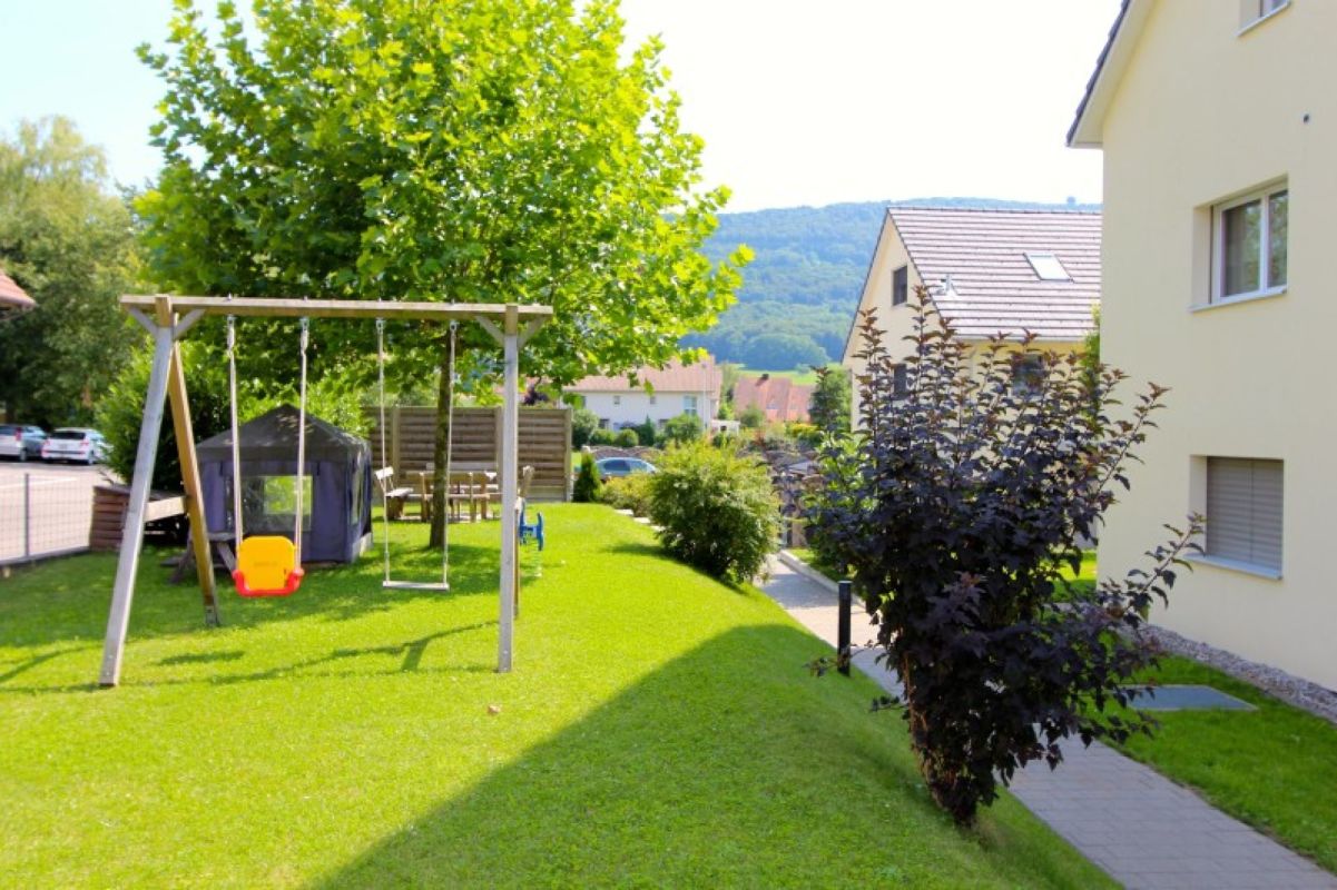Garten mit Spielbereich und Wohnhäusern