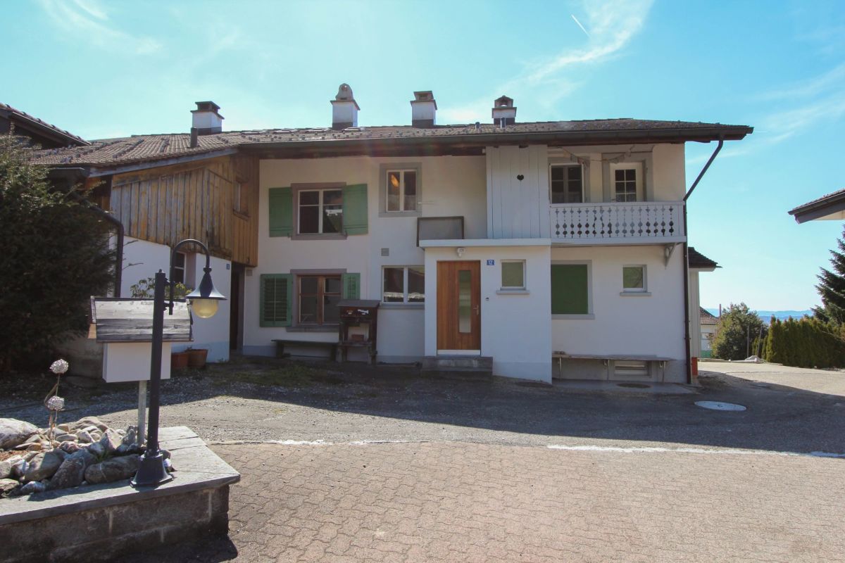 Landhausfassade mit Balkon und Holzakzenten