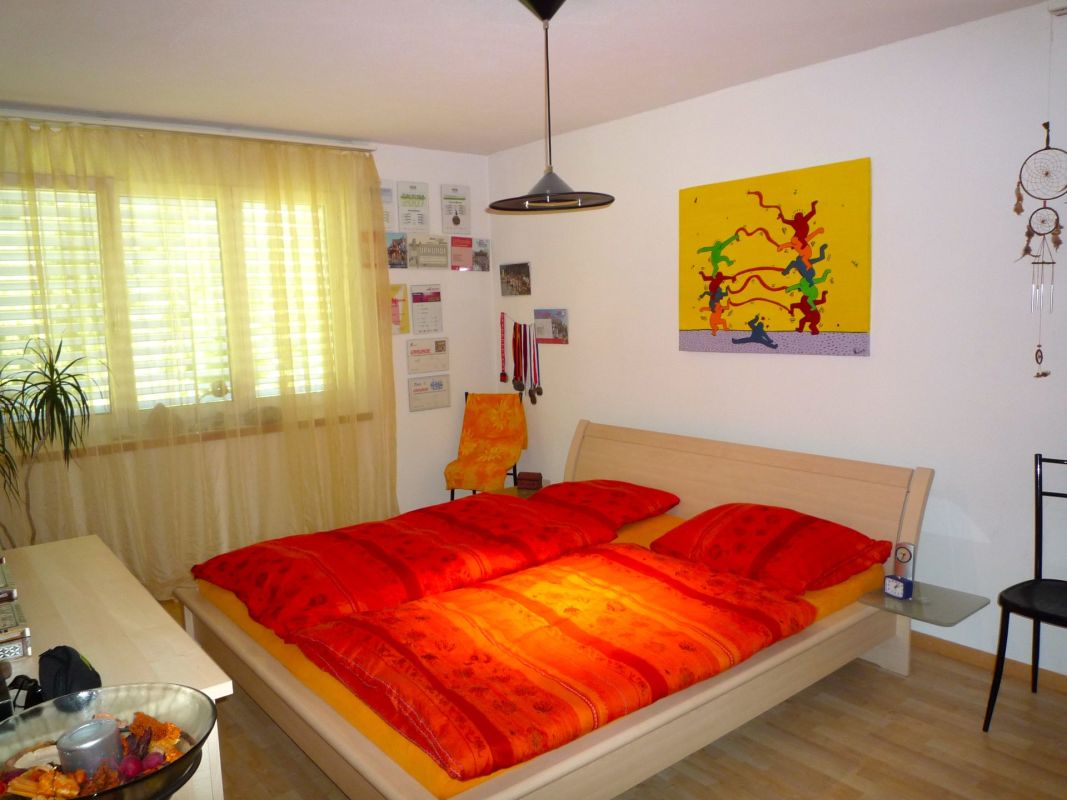 Schlafzimmer mit Doppelbett und farbenfroher Wandgestaltung