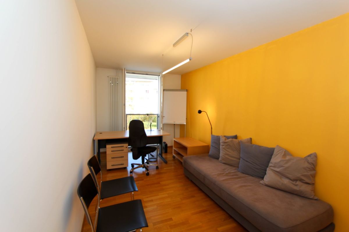 Kompaktes Wohn-/Arbeitszimmer mit Sofa und Schreibtisch