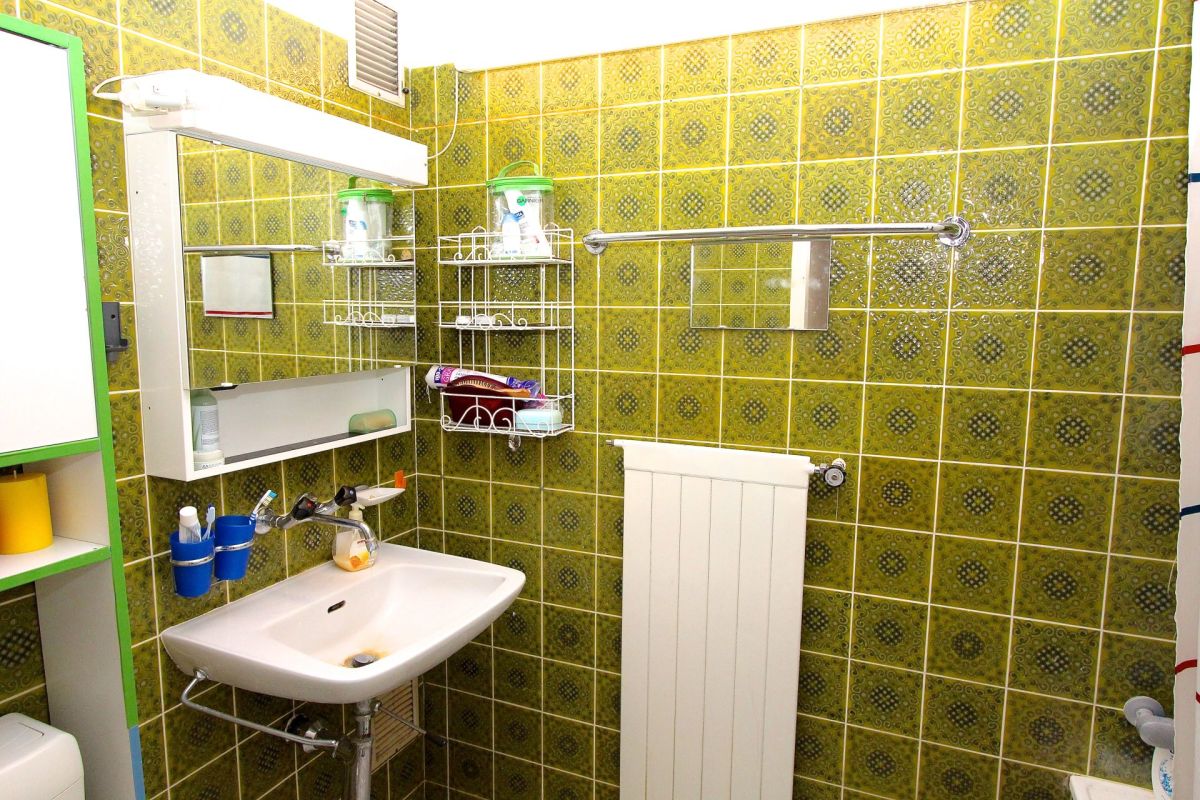 Grün gefliestes Badezimmer mit Waschbecken