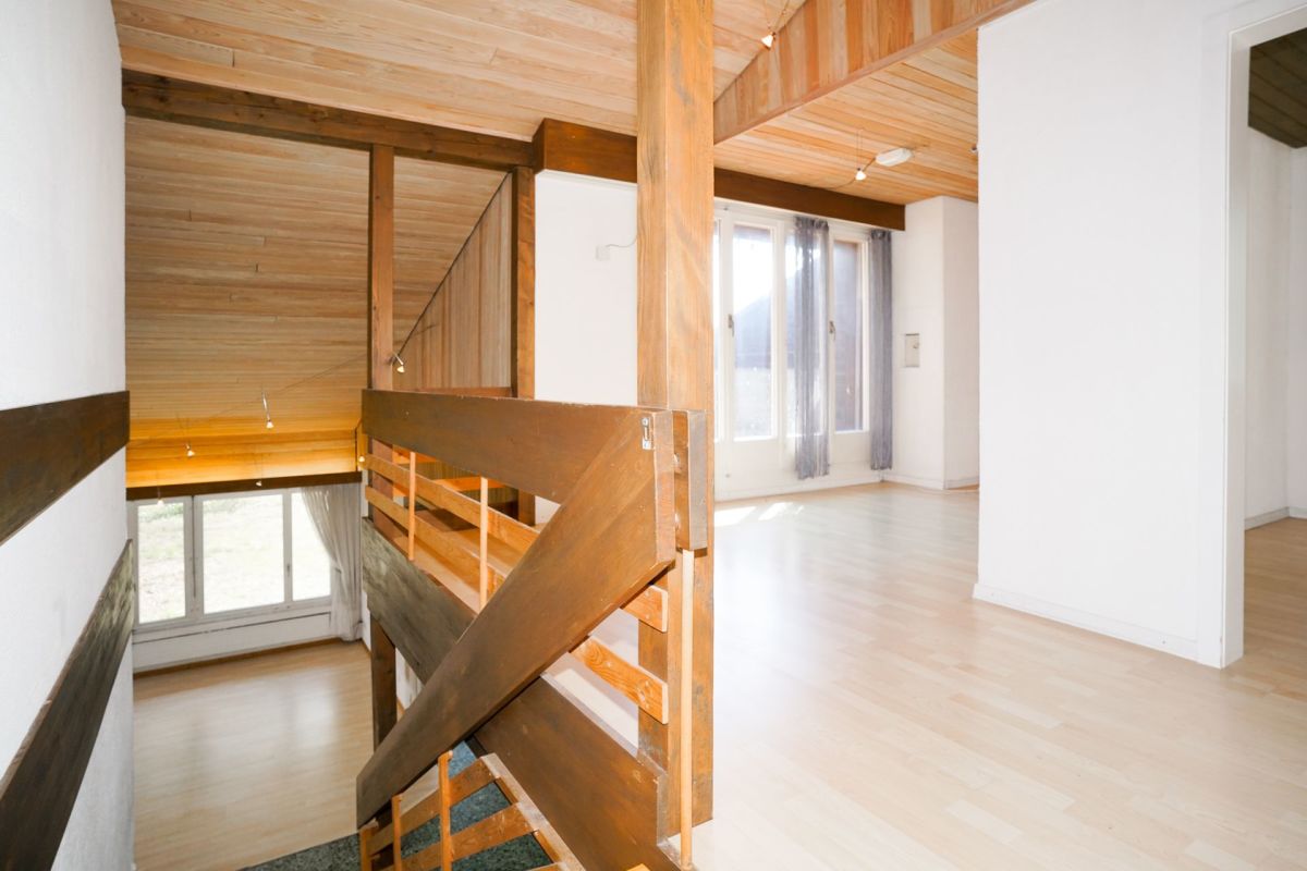 Offener Wohnbereich mit Treppe und Holzdecke