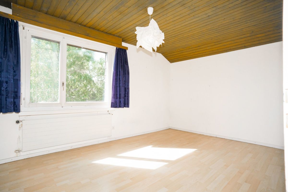 Helles, leeres Zimmer mit Holzdecke