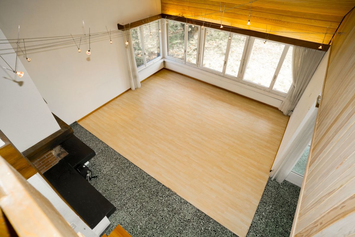 Heller Wohnraum mit großen Fenstern und Holzdecke