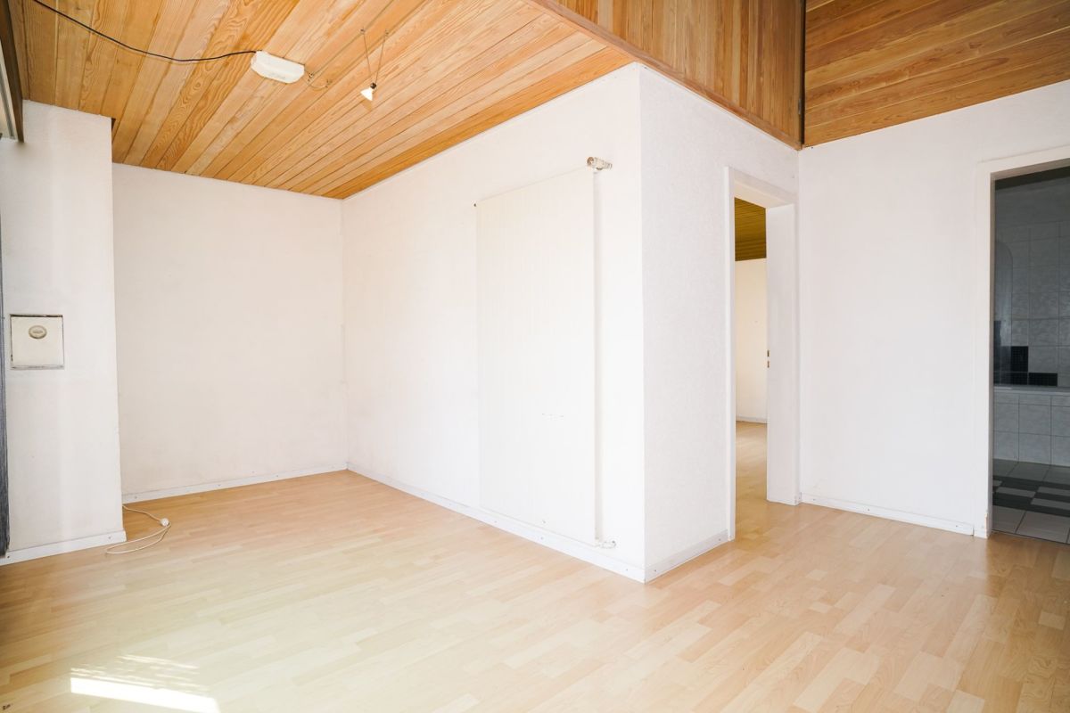 Heller leerer Raum mit Holzdecke und Laminatboden