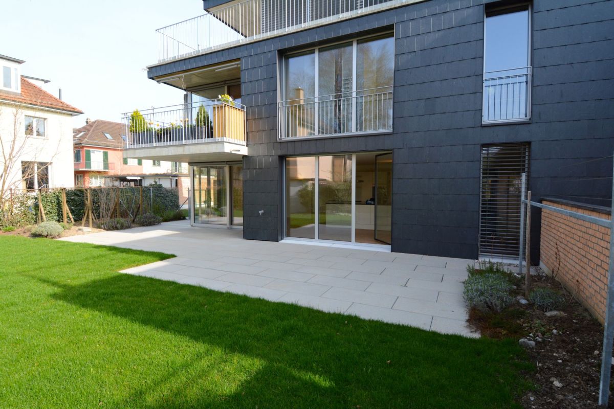 Moderne Hausfassade mit Balkon und Garten