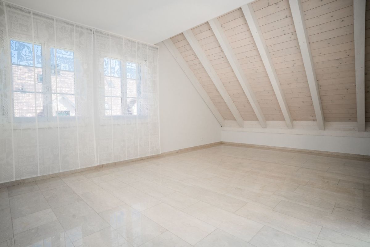 Heller Dachraum mit Holzdecke und großen Fenstern