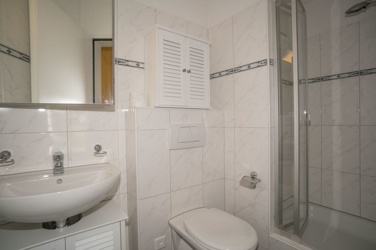 Helles Badezimmer mit Dusche und Waschtisch