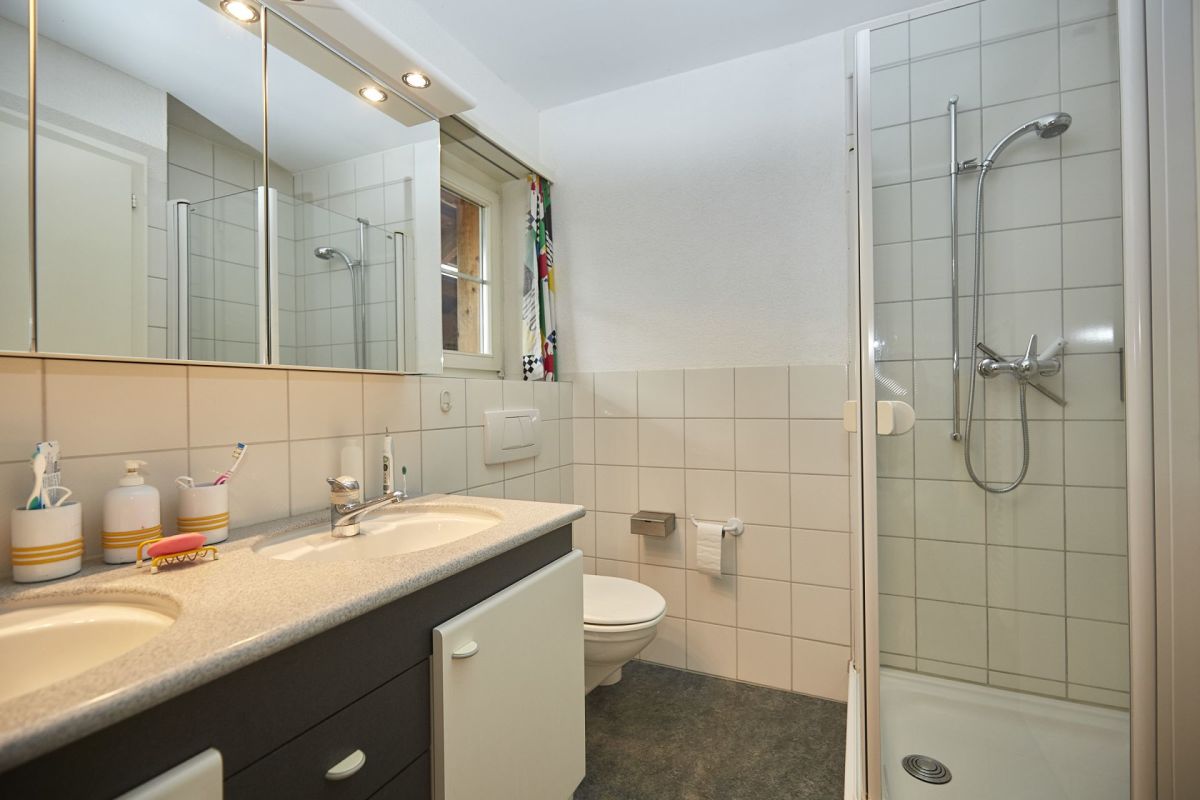 Badezimmer mit Doppelwaschbecken und Dusche