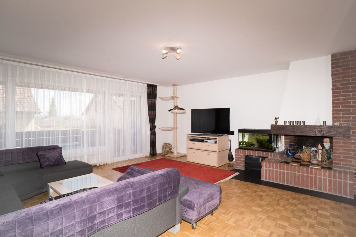 Wohnzimmer mit Kamin und großer Fensterfront